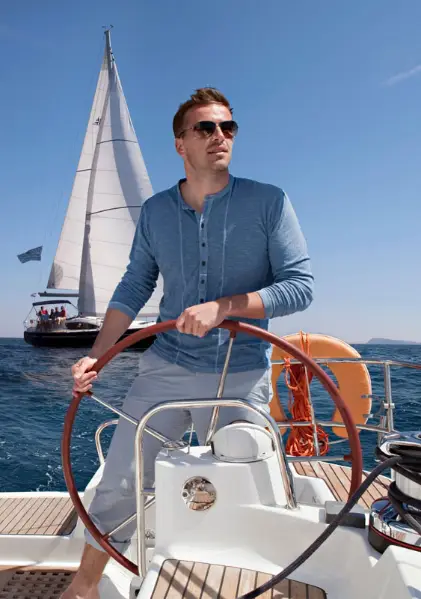 Man steering sailboat dubai charter